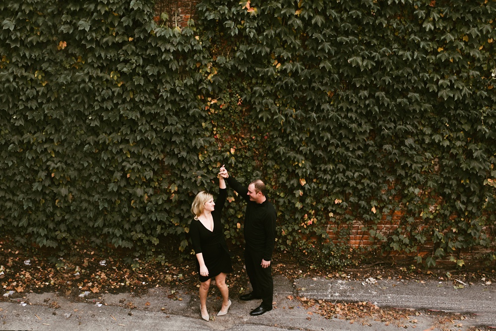 couple holding hands next to ivy at downtown fort wayne engagement session