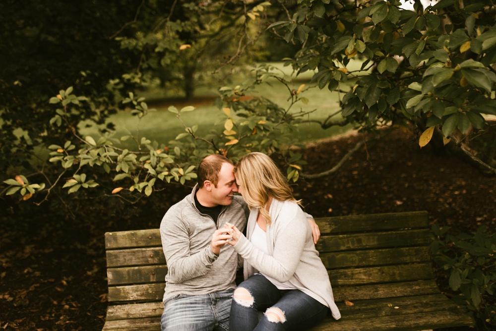 couple sitting on bench at downtown fort wayne engagement session