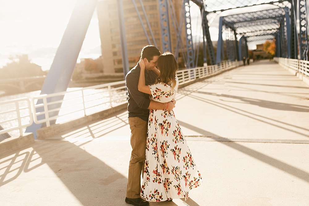 couple hugging on bridge at downtown grand rapids engagement session
