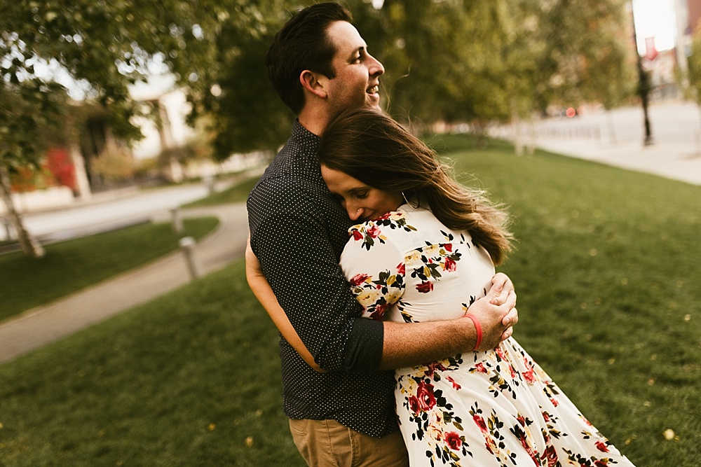 couple hugging in park at downtown grand rapids engagement session