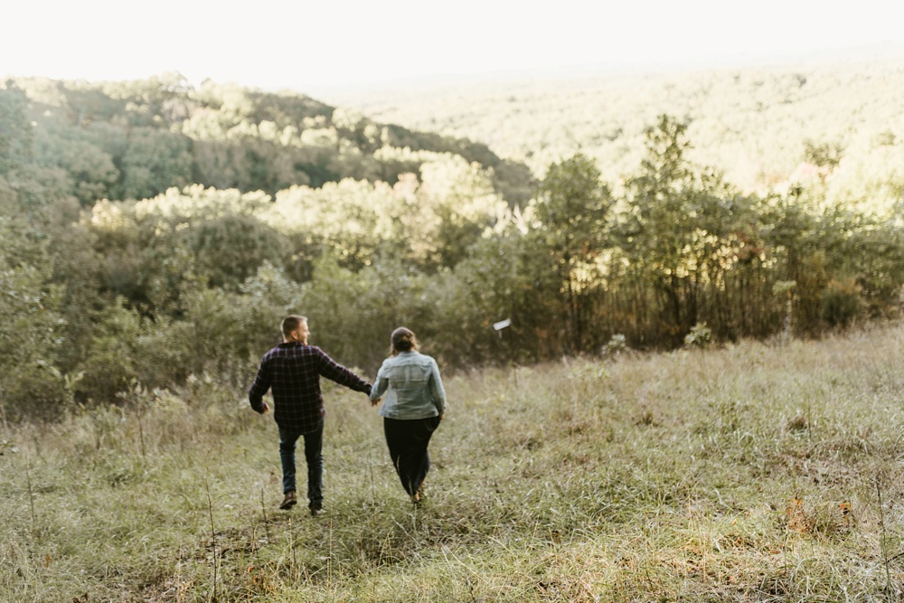 couple running through woods at brown county engagement session