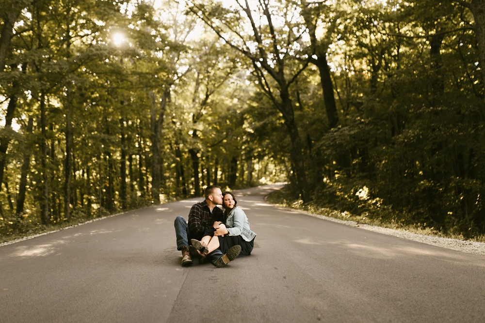 couple wrestling in road at brown county engagement session