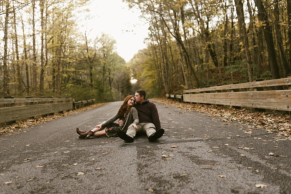 couple kissing on path at chain o'lakes fall engagement session