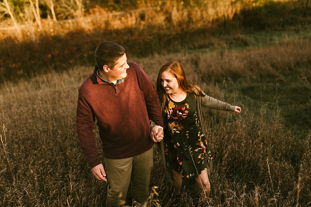 couple holding hands at sunset at chain o'lakes fall engagement session