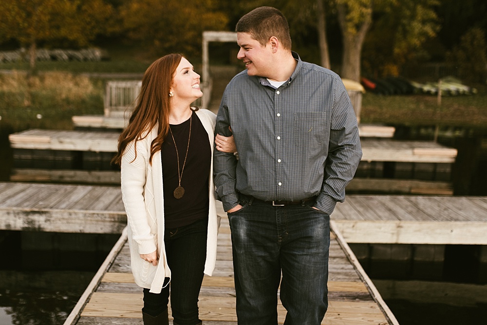 couple standing arm and arm in pier at chain o'lakes fall engagement session