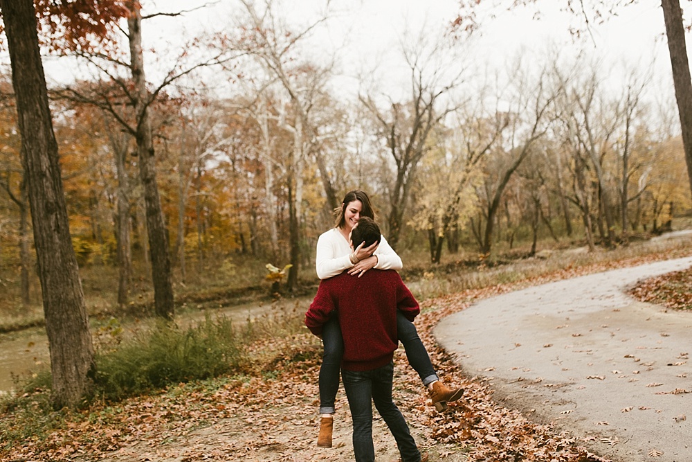 man holding fiance at cataract falls fall engagement session