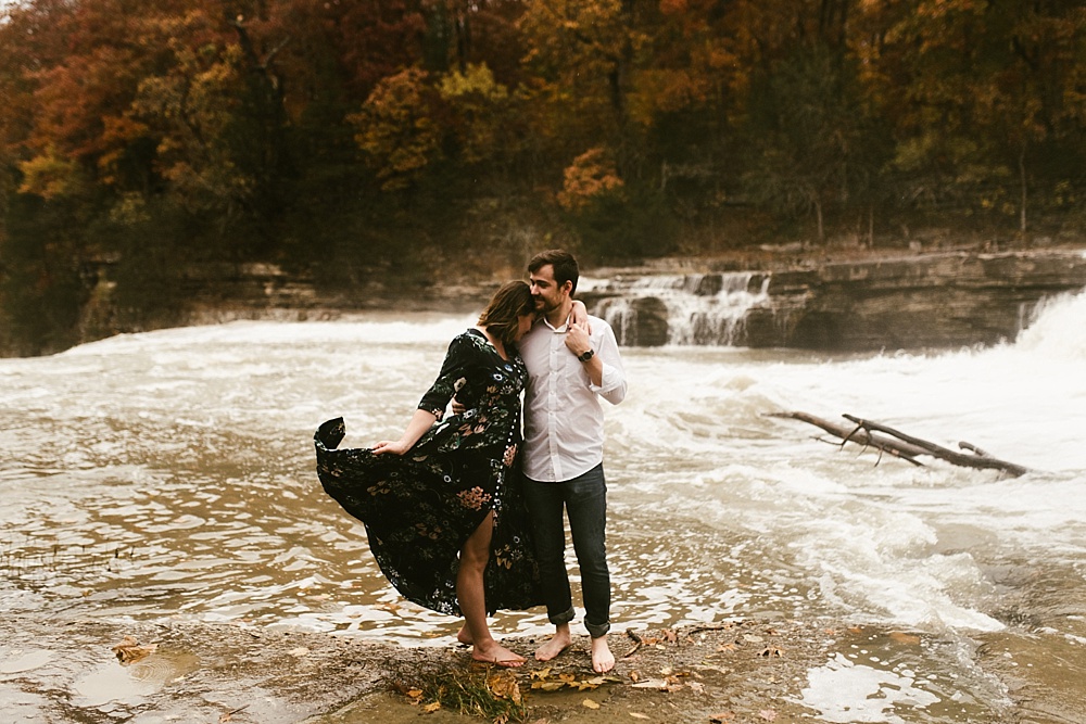 couple walking through water at cataract falls fall engagement session