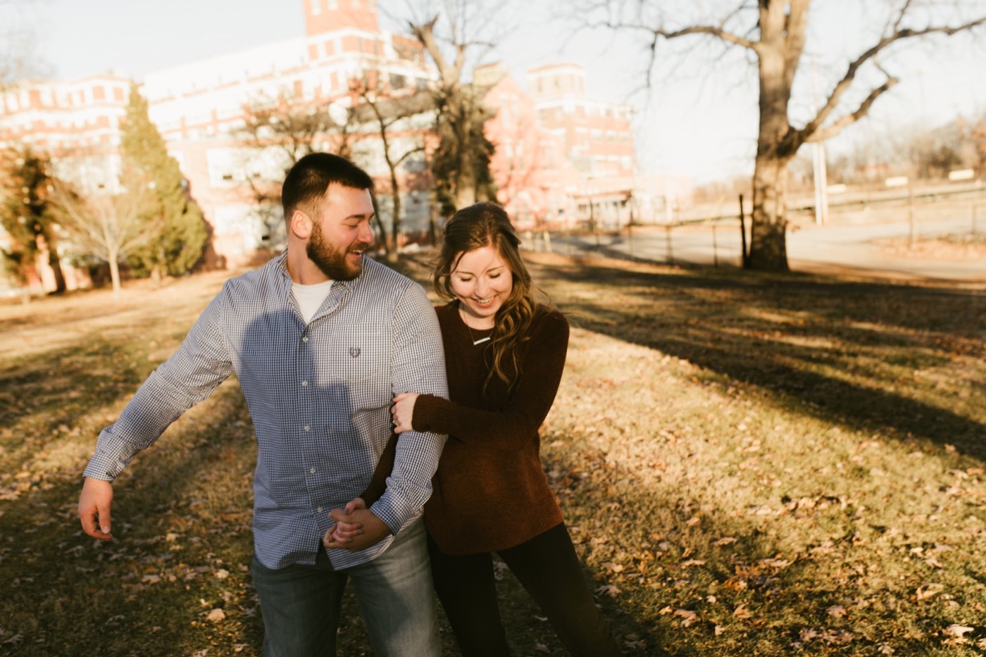 couple holding hands on GE campus at downtown fort wayne engagement session