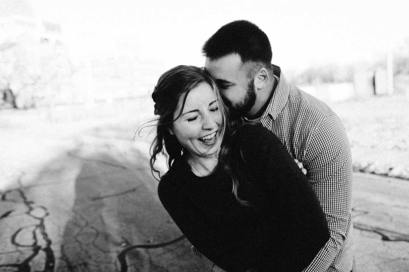 couple kissing and laughing at downtown fort wayne engagement session