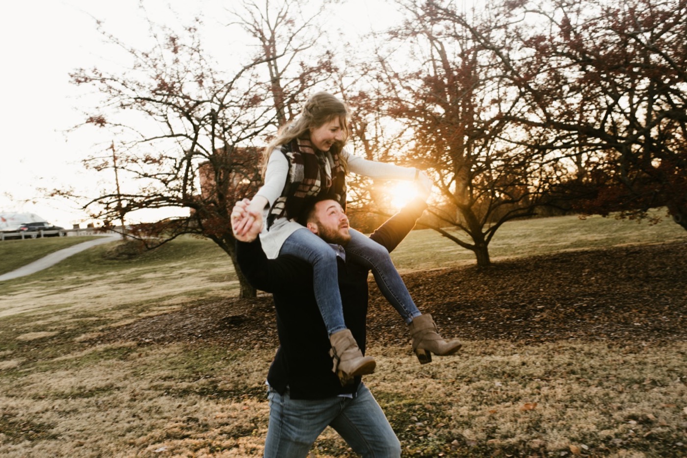 couple doing shoulder ride at golden hour at downtown fort wayne engagement session