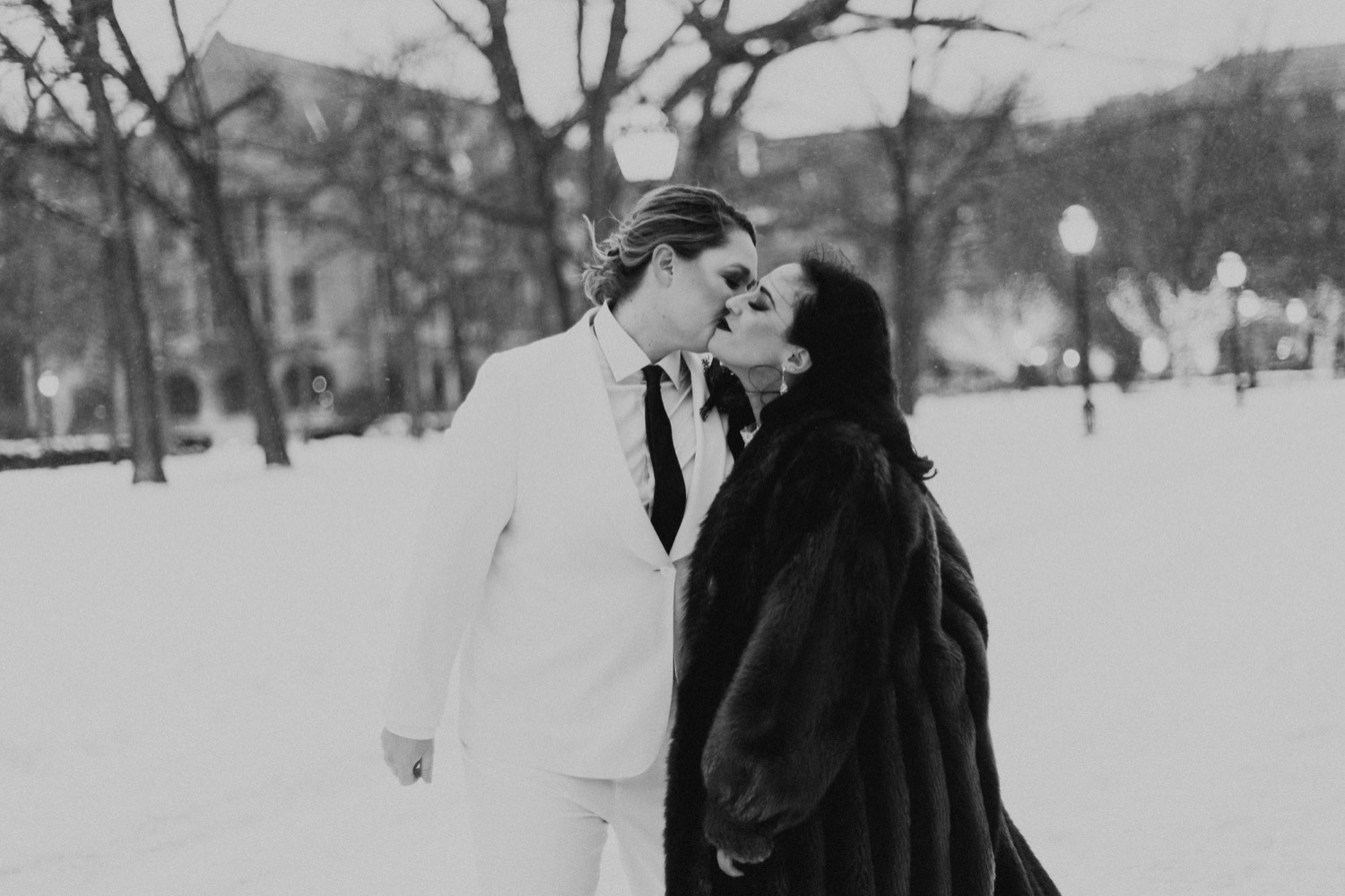 Black and white photo of Chicago brides kissing in the snow.