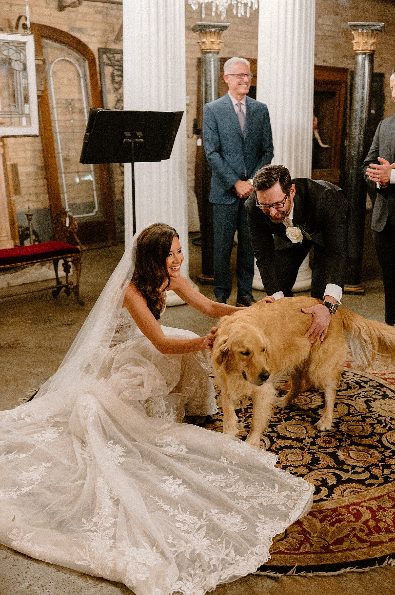 Bride and groom stop to pet their dog in the middle of their ceremony. 