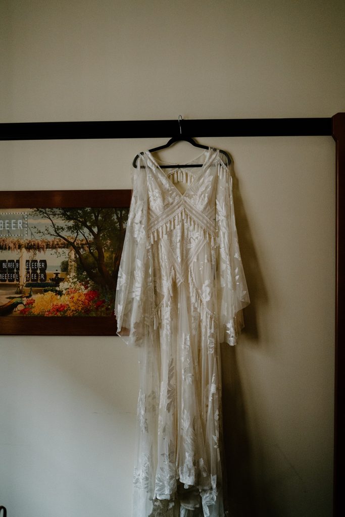 Boho wedding dress hanging in front of picture for Fall wedding in Chicago. 