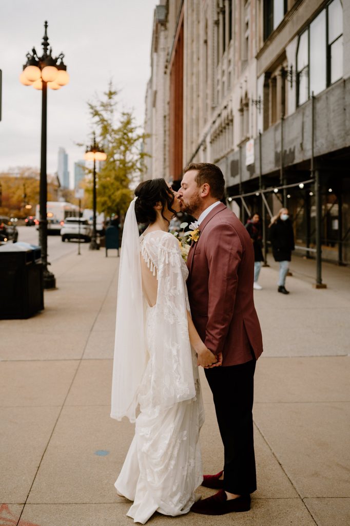 Bride and groom stealing a kiss in the middle of the sidewalk in downtown Chicago. 