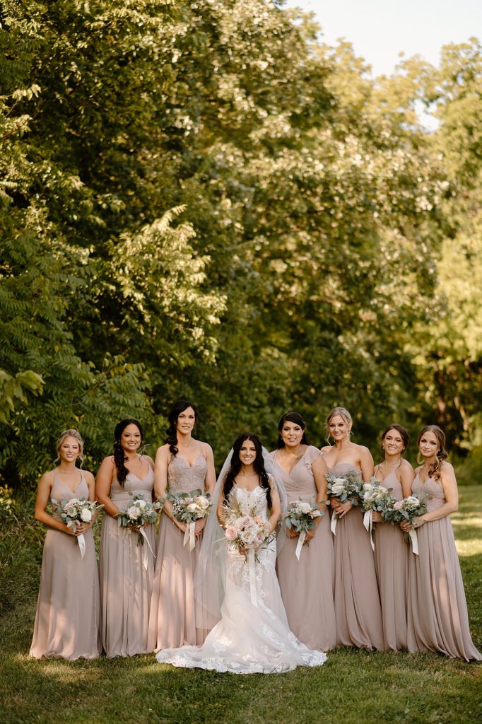 Bride and bridesmaids in a field by Fort Wayne photographer, Indigo Lace. 