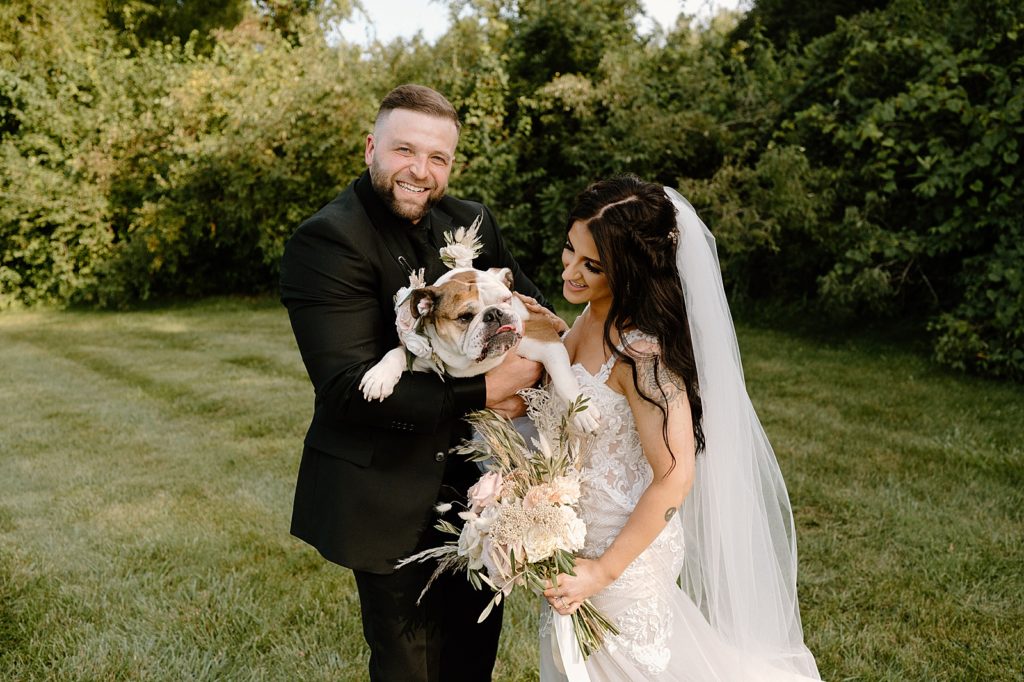 Bride and groom holding their dog for a portrait by Fort Wayne wedding photographer, Indigo Lace. 