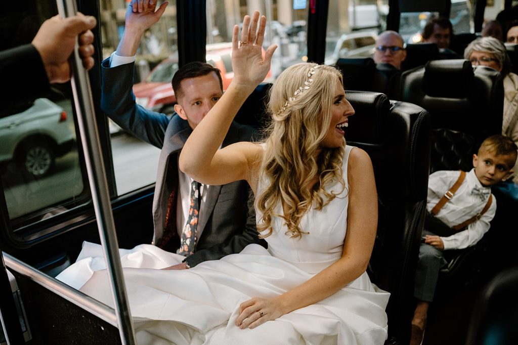 Bride and groom on a bus with their family on their way to Salvage One Chicago Spring wedding