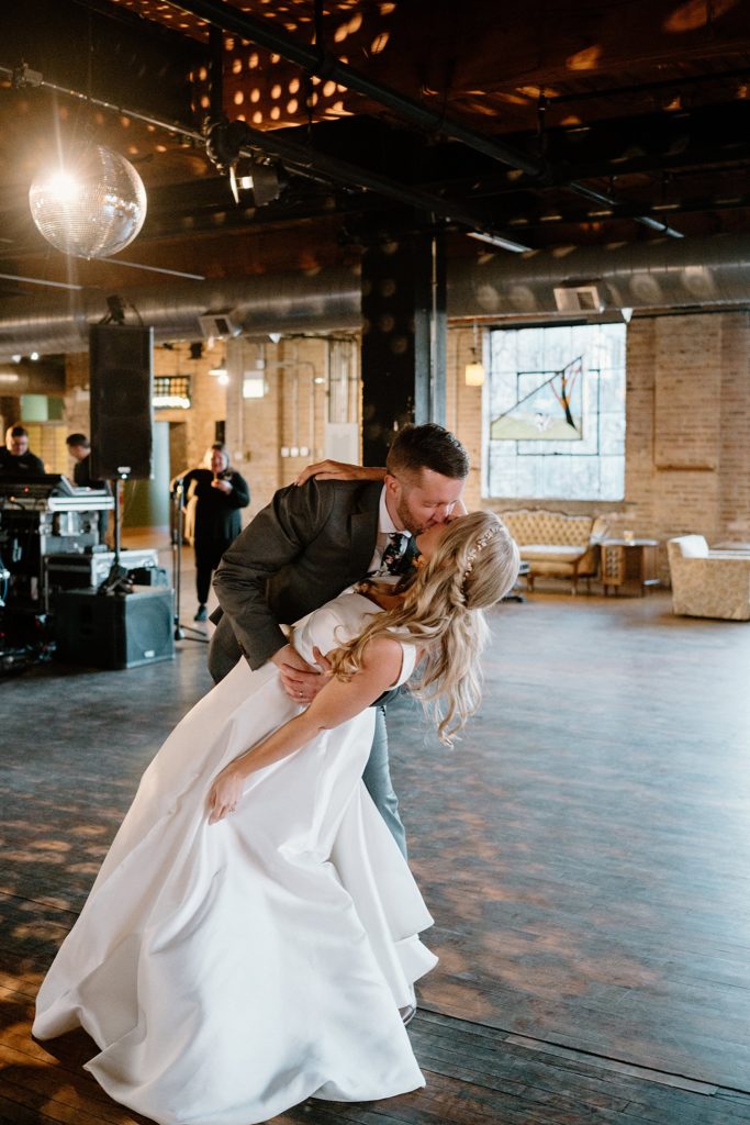 Newlyweds share a kiss on the dance floor at their boho reception 