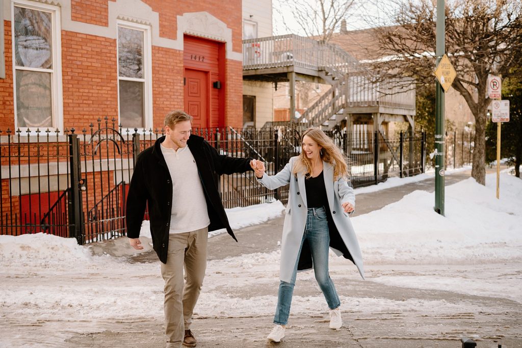 Couple walks through snowy street for Bucktown Engagement Session