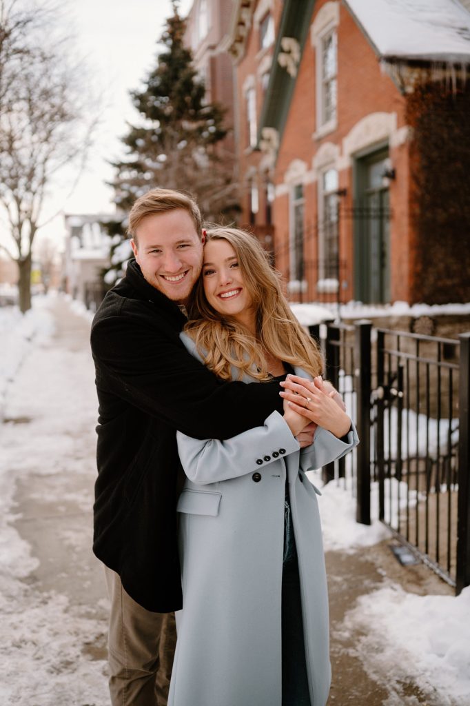 Happy couple embracing for snowy Bucktown Engagement Session