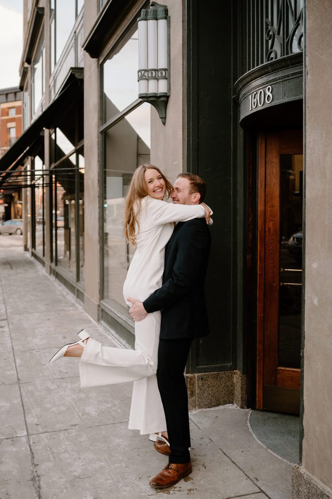 Man holding a woman in an embrace on a downtown street by Chicago wedding photographer Indigo Lace