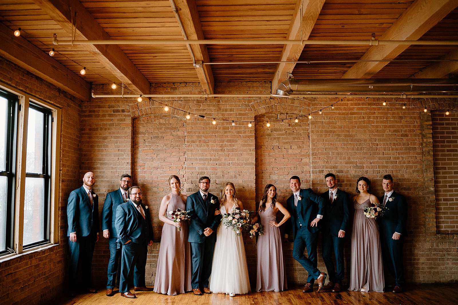 Full wedding party in pink and blue in a warehouse venue 