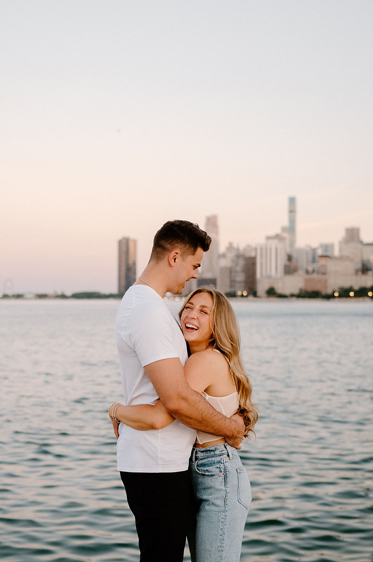 young couple hug and laugh during Grant Park and Chicago Skyline Engagement Session