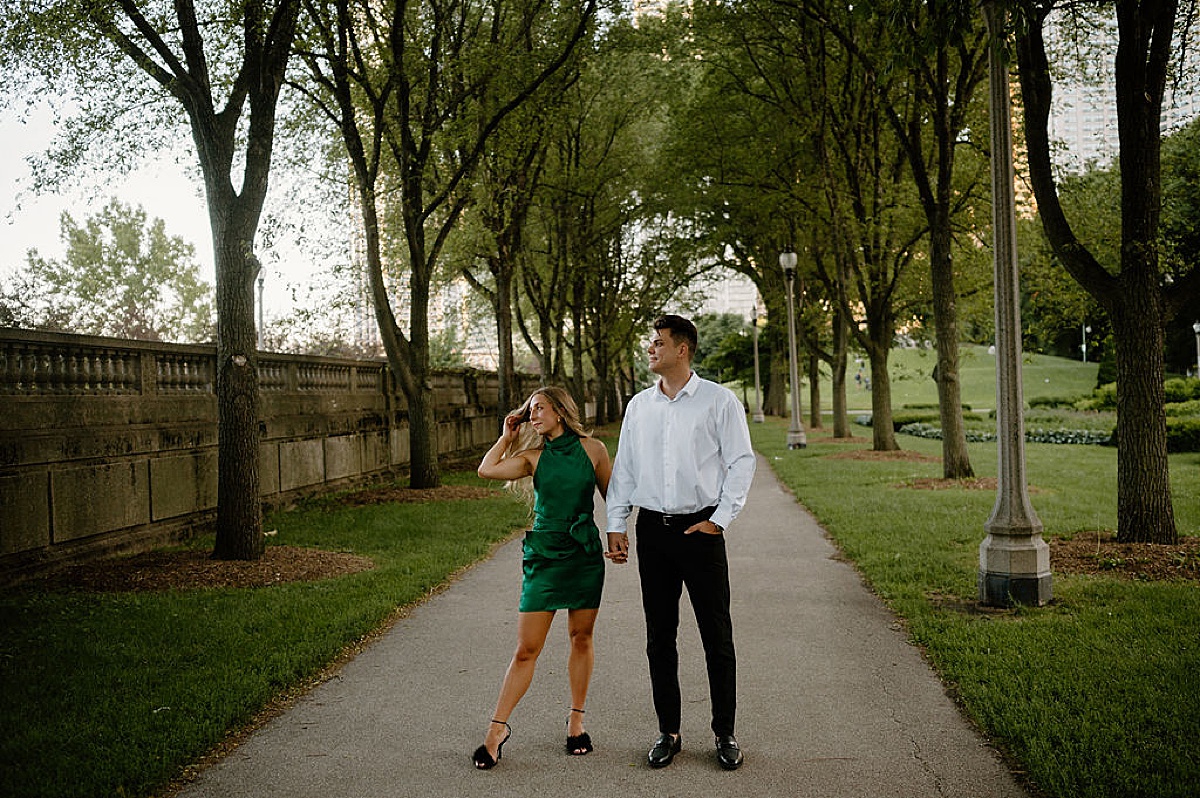 elegant couple walk hand in hand through garden during Grant Park and Chicago Skyline Engagement Session