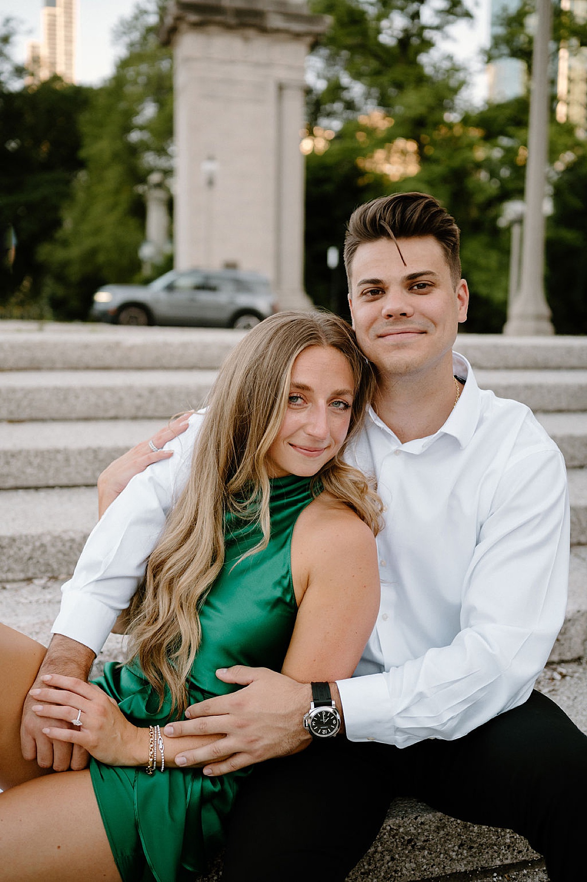 woman in green satin dress poses with fiance during engagement shoot by Indigo Lace Collective