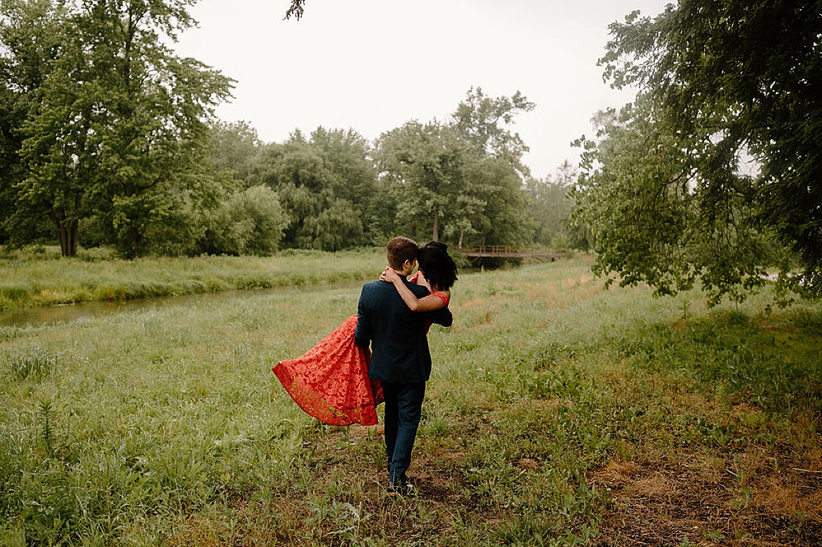 man sweeps his fiancee off her feet during romantic engagement shoot with midwest wedding photographer