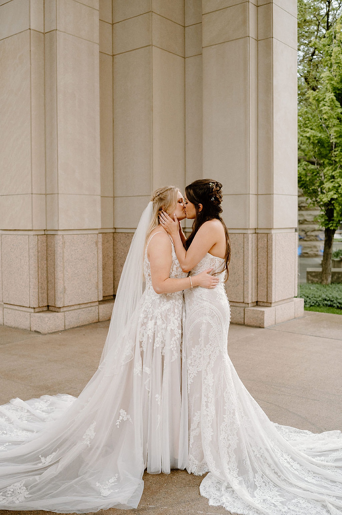Two brides in beautiful lace gowns kiss at same sex wedding at BASH Indianapolis