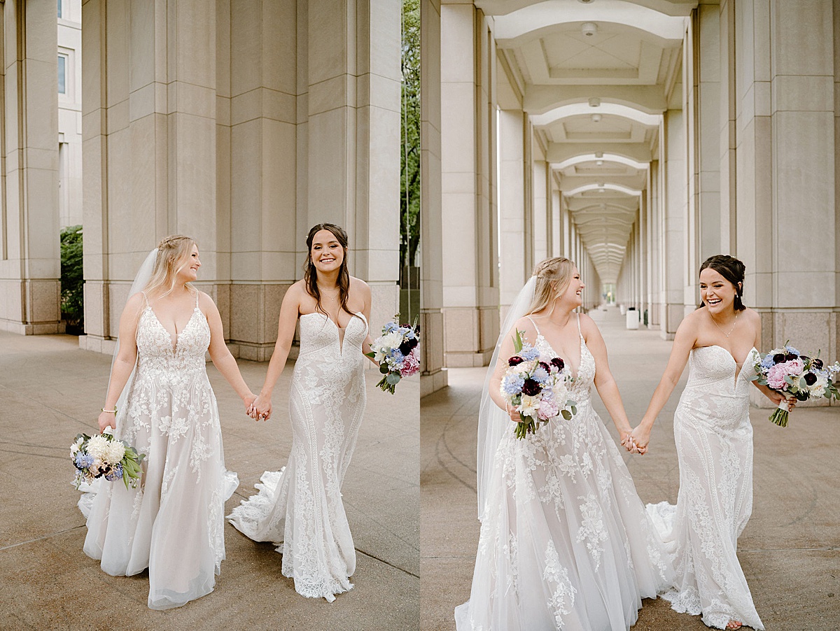 Two blushing brides hold hands and smile before elegant ceremony shot by midwest wedding photographer