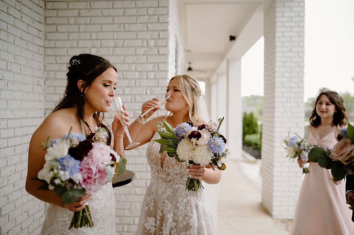 Newlywed brides toast champagne after Indianapolis wedding shot by Indigo Lace Collective