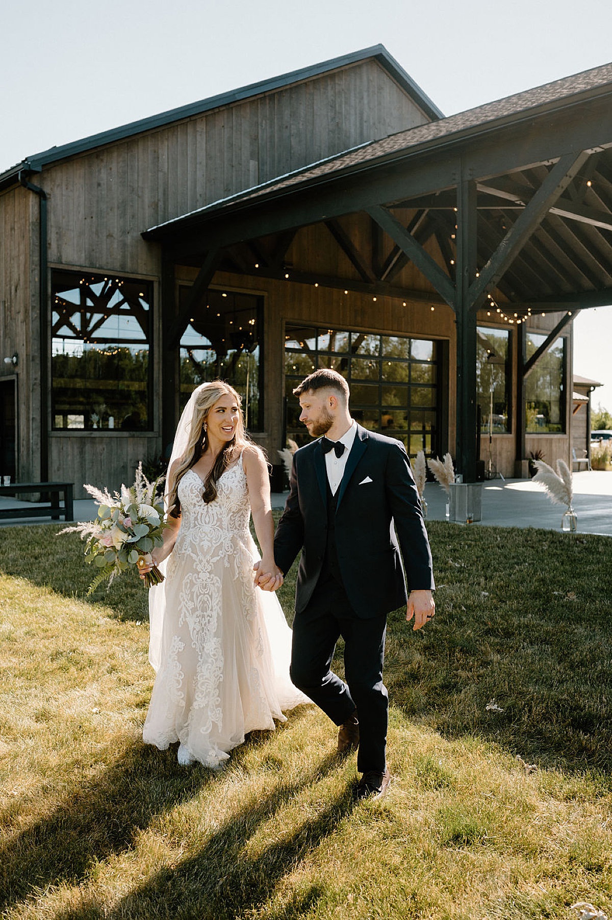 boho bride and groom pose outside venue before reception shot by midwest wedding photographer