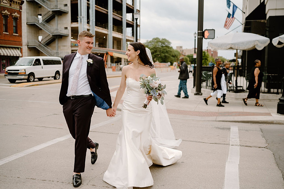 elegant newlywed couple cross the street after Heartfelt Paper Mill on the Landing Wedding
