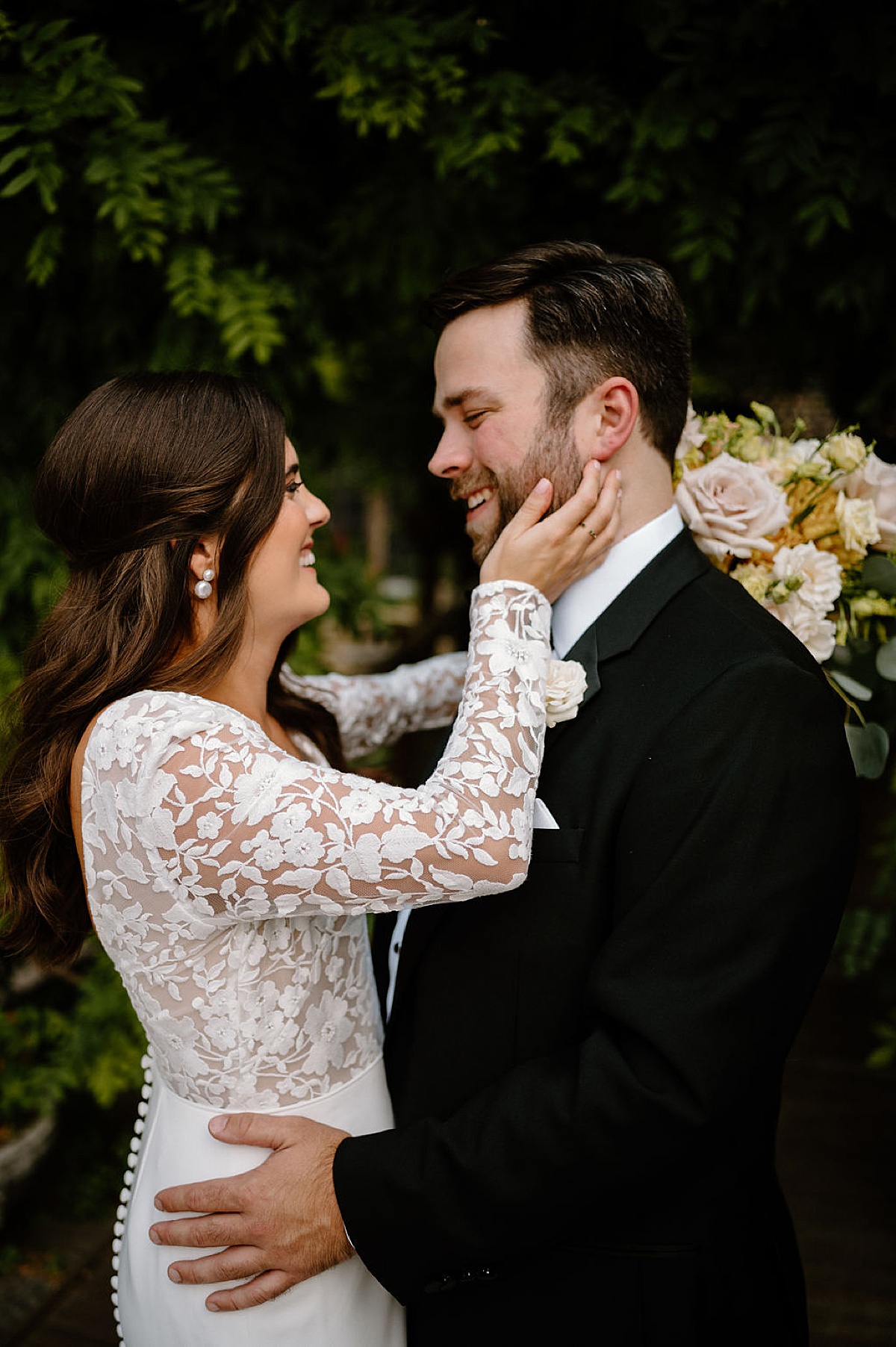 elegant boho bride laughs and hugs groom in black tux after wedding shot by Indigo Lace Collective