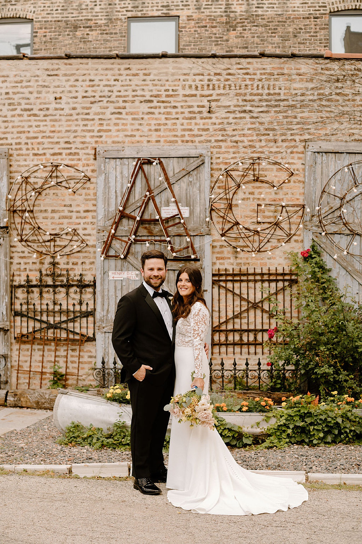 boho bride and groom pose at reception venue in midwest shot by chicago wedding photographer