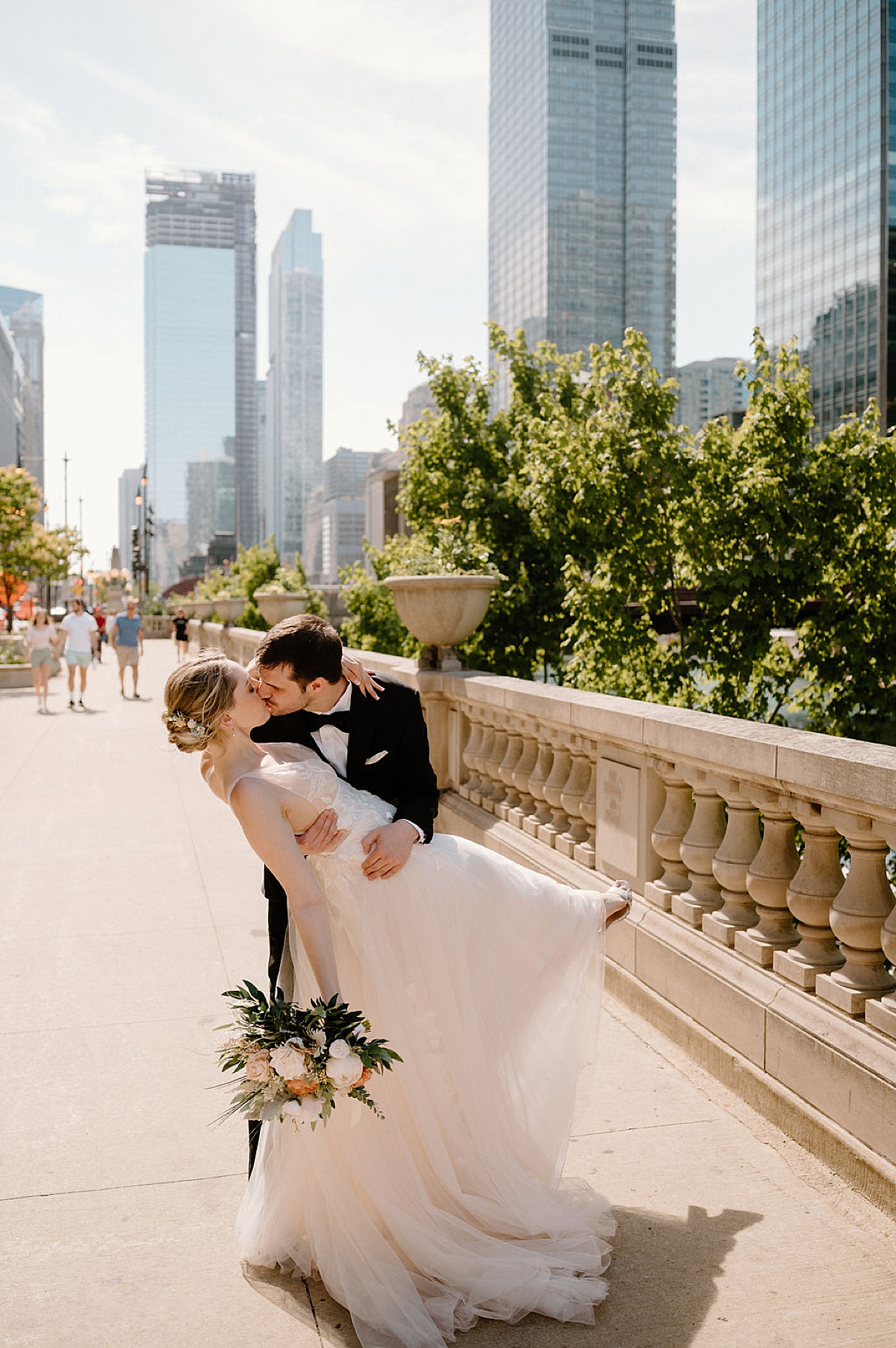 Romantic bride and groom kiss on chicago bridge before a Whimsical  Summer Wedding