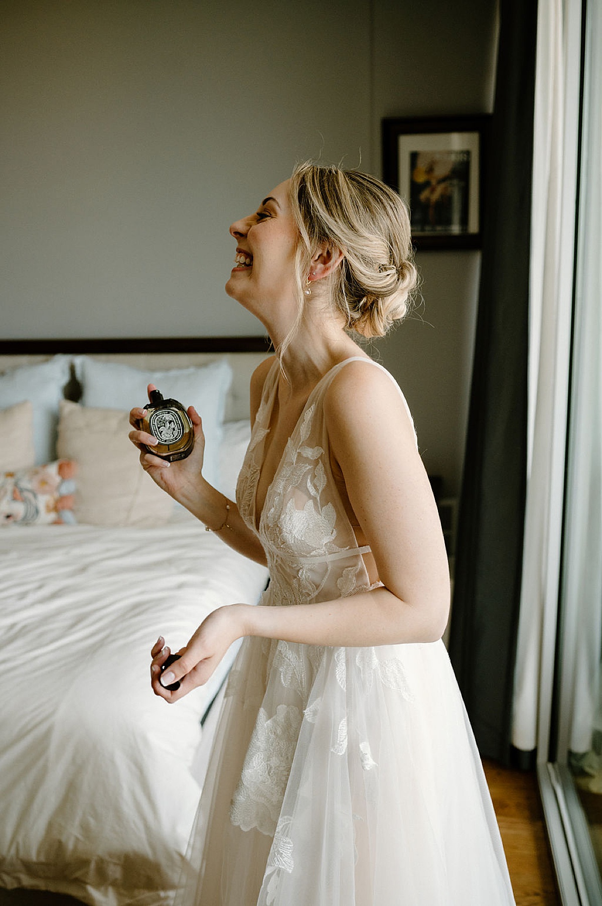 bride in romantic tulle gown spritzes perfume before a Whimsical Summer Wedding