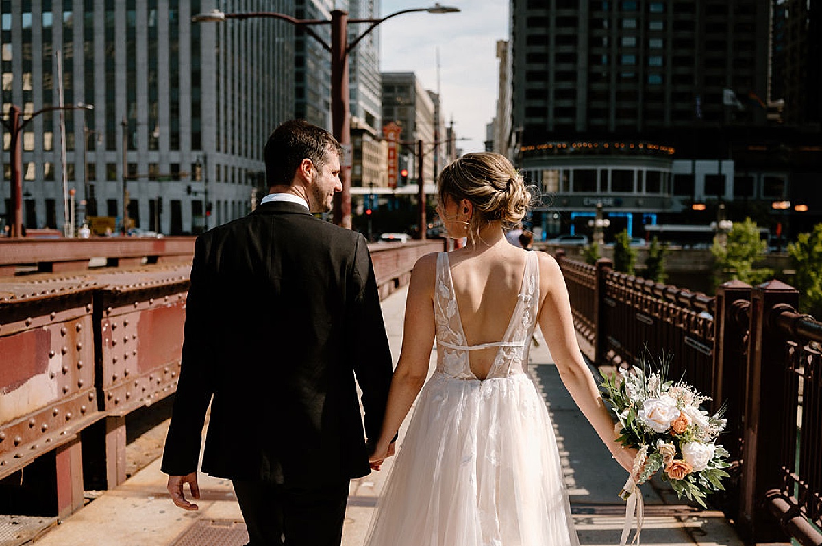 bride and groom walk romantic iron bridge before ceremony shot by chicago wedding photographer