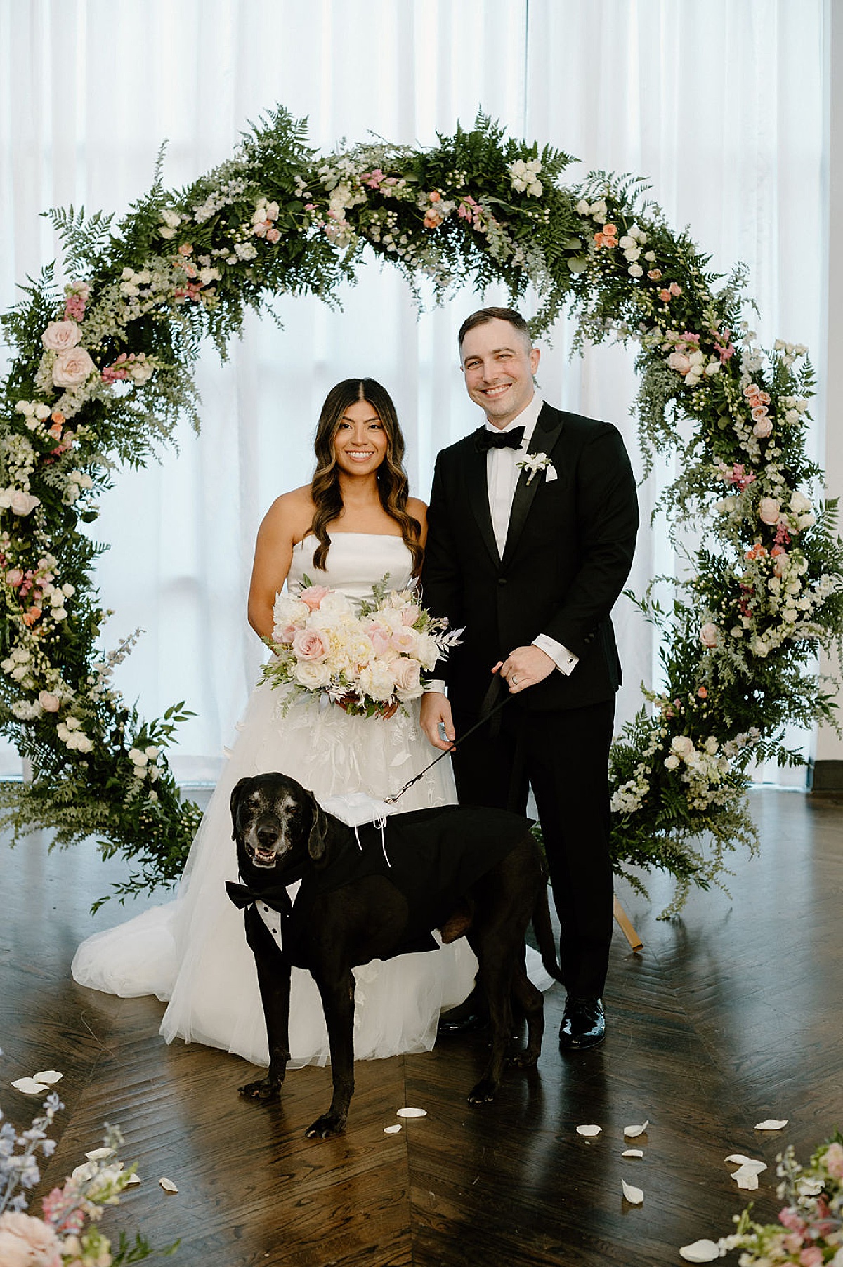 classy bride and groom pose with ring bearer puppy after ceremony shot by Chicago wedding photographer