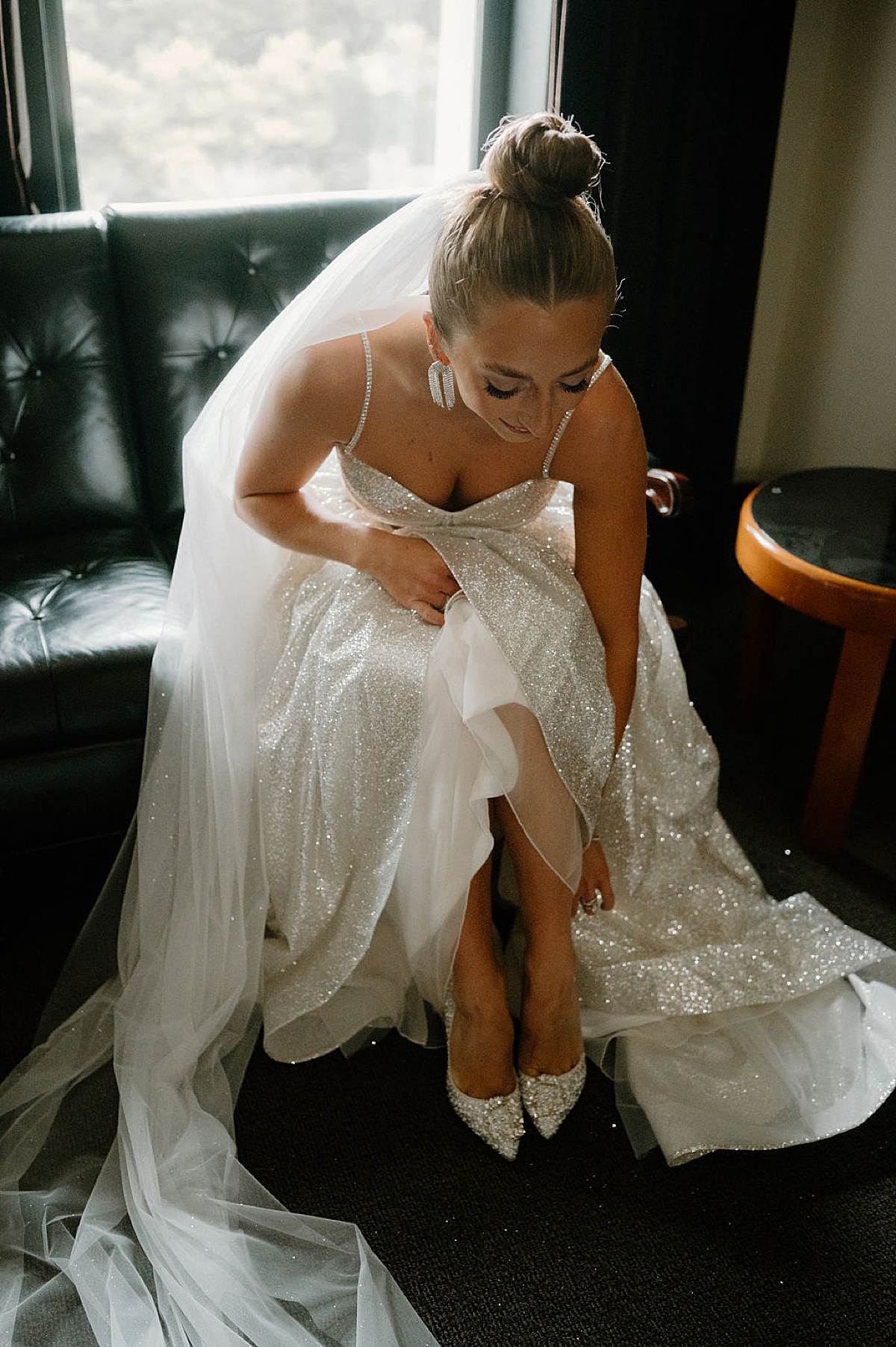 gorgeous bride in sparkling gown puts on gem encrusted high heels before Glitz & Glam Chicago Wedding