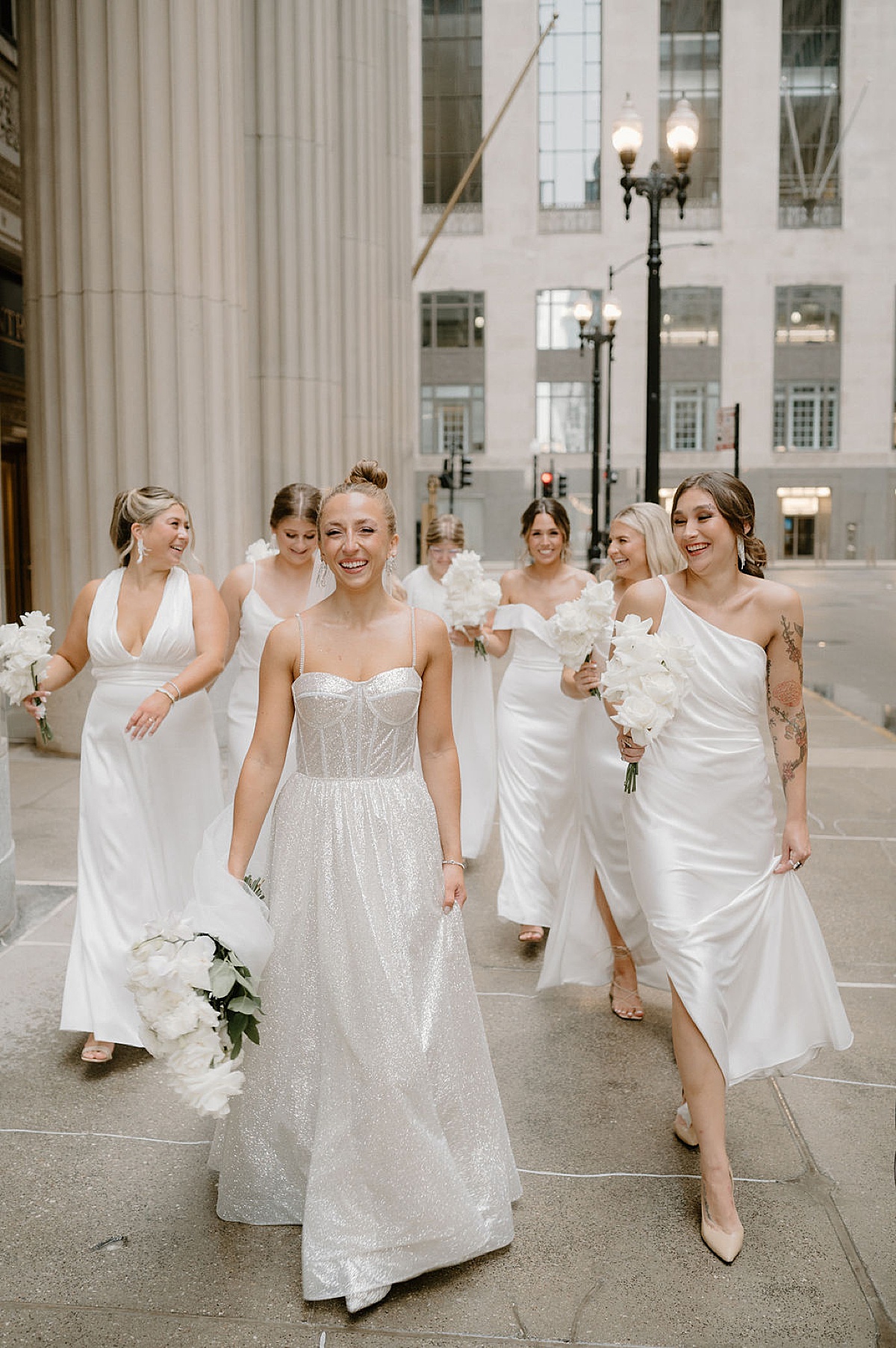 bride in sequin wedding gown poses with bridesmaids in white dresses shot by Midwest wedding photographer 