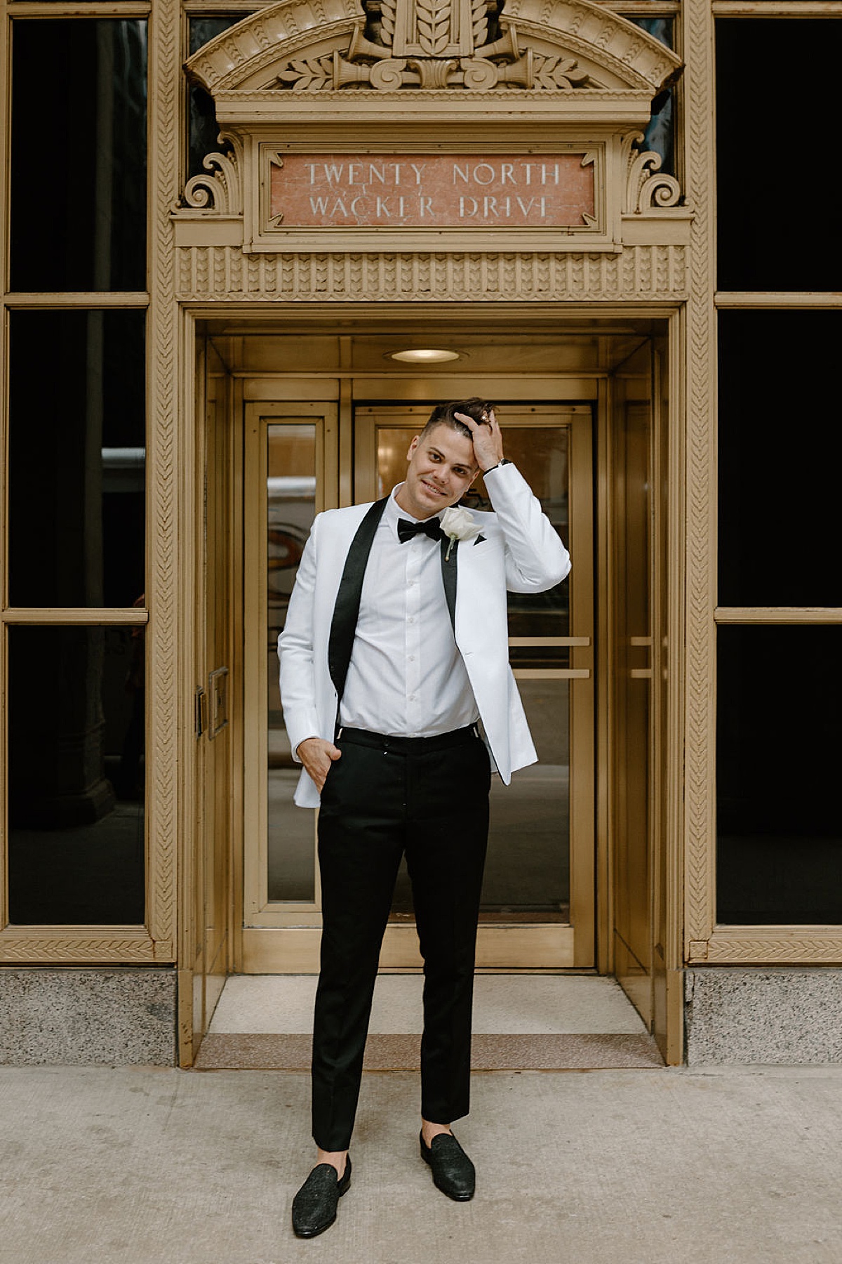 broom in sharp white jacket and sparkly black brogues poses in front of gold door in Chicago | Midwest wedding photographer 