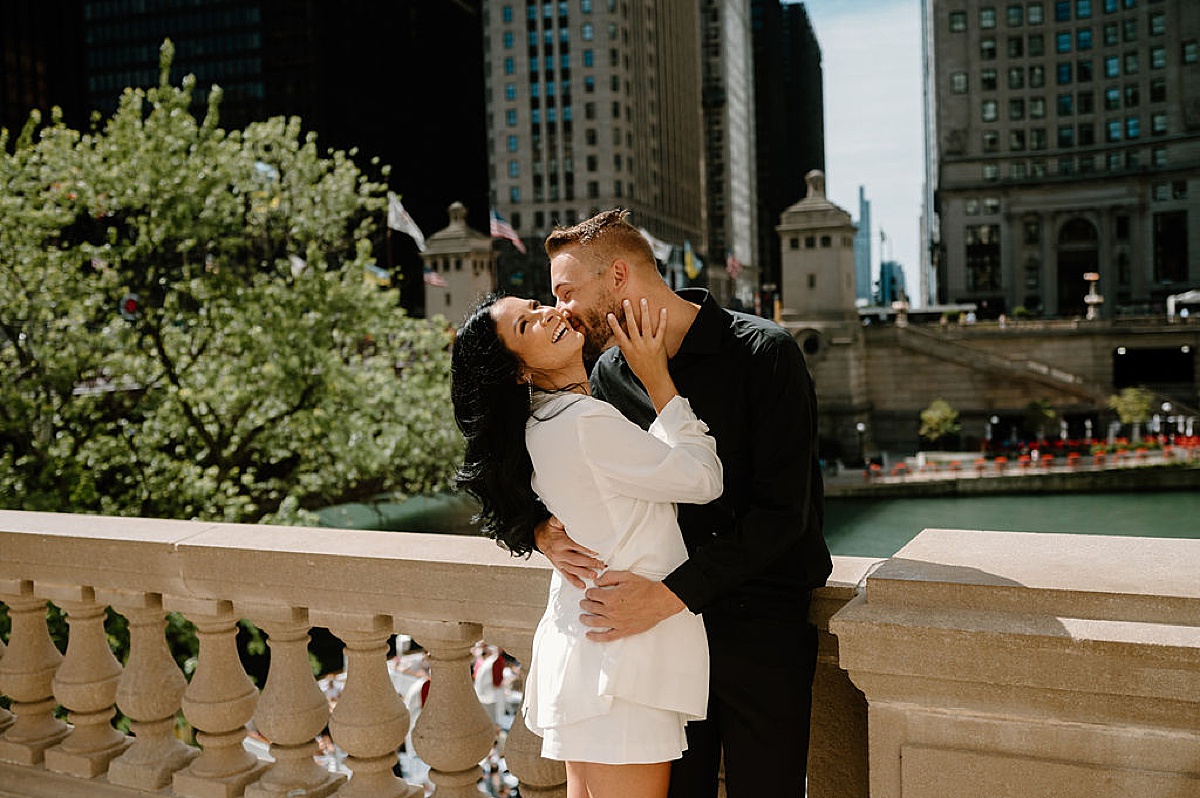 man and woman kiss on Chicago bridge during classy big city engagement session