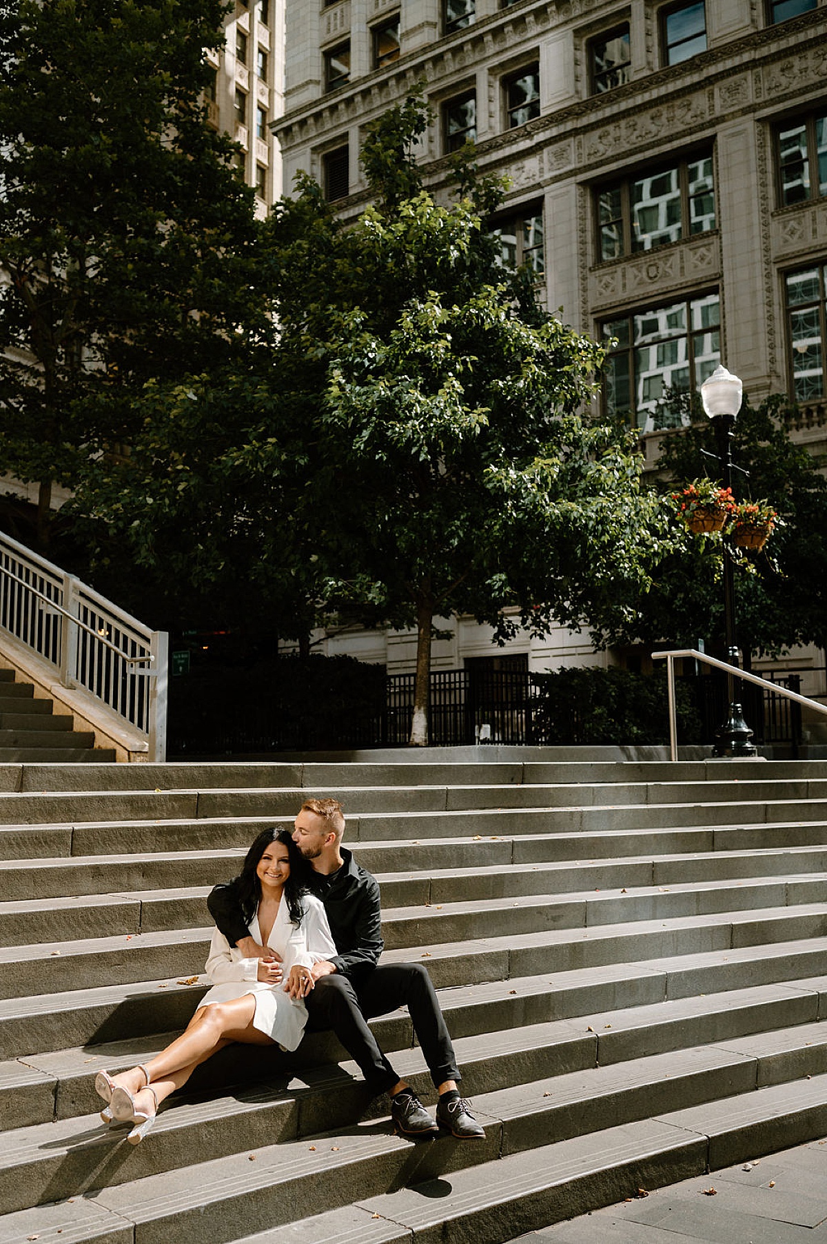 cute modern couple pose on steps and hug during big city engagement session