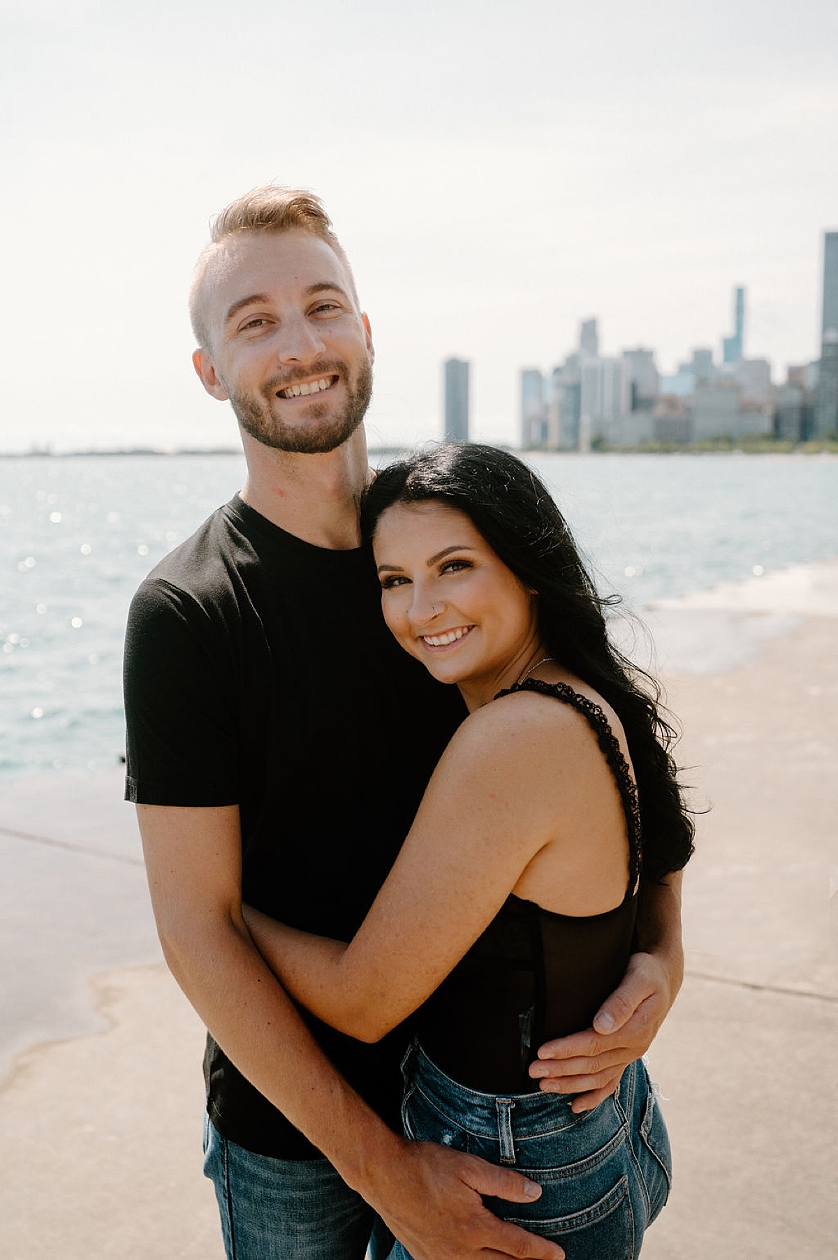 young couple pose arm in arm during hip engagement shoot with Indigo Lace Collective