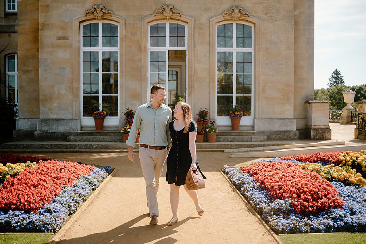 newly engaged couple walk hand in hand through English garden during Wrest Park Engagement session