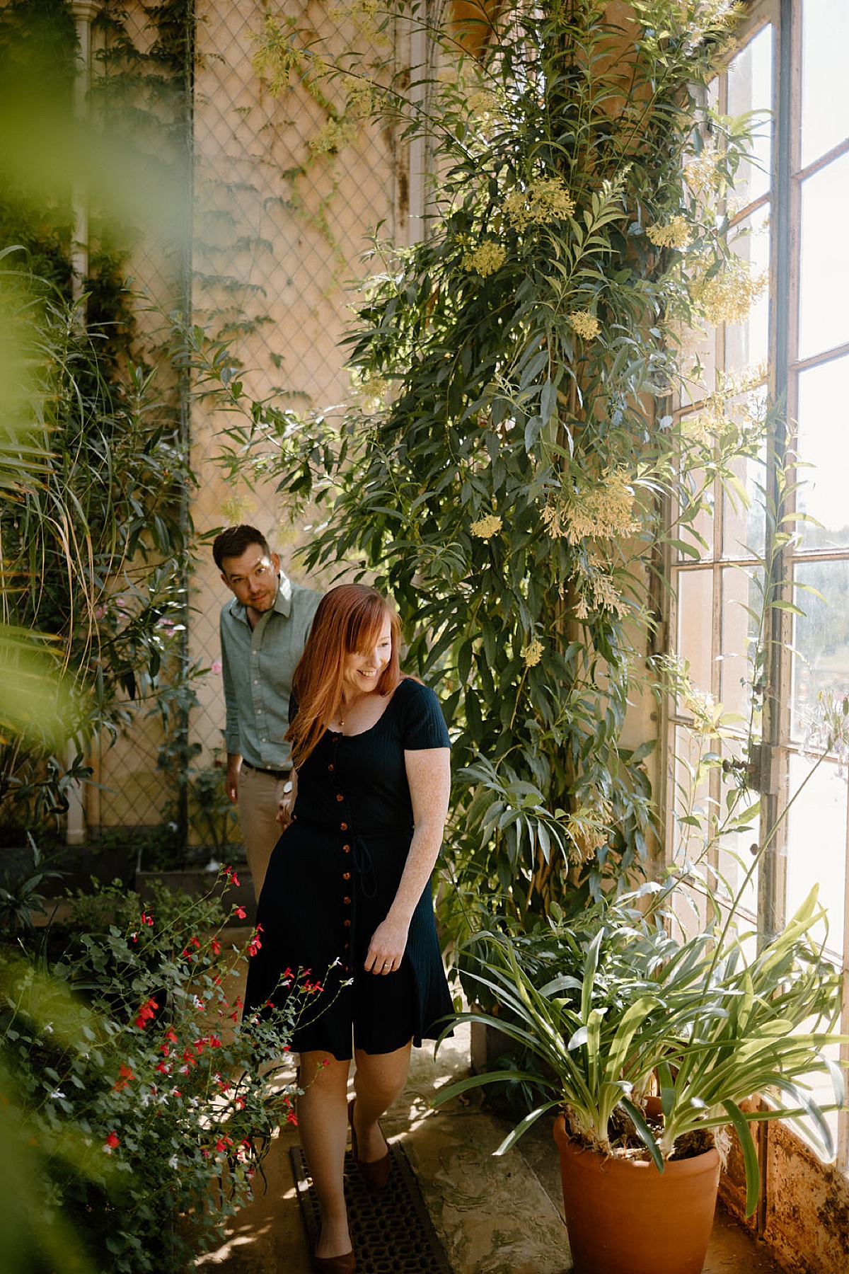 couple in casual daywear explore old greenhouse during Wrest Park Engagement session