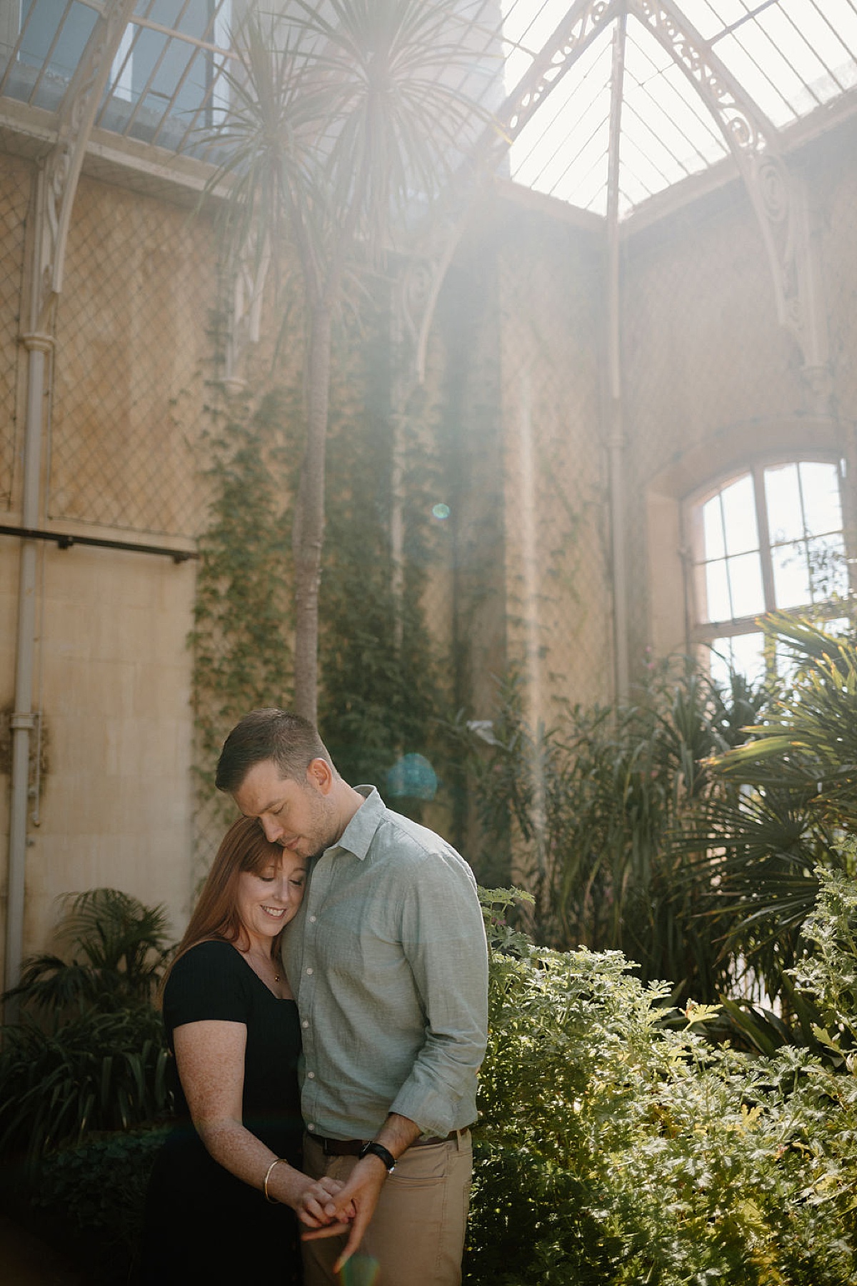 couple embraces during romantic London greenhouse engagement shoot with Indigo Lace Collective
